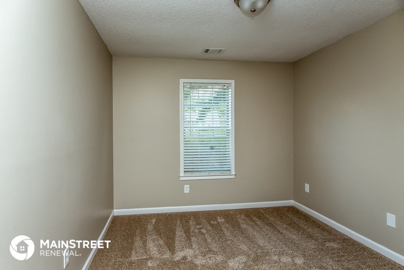 an empty room with carpet and a window