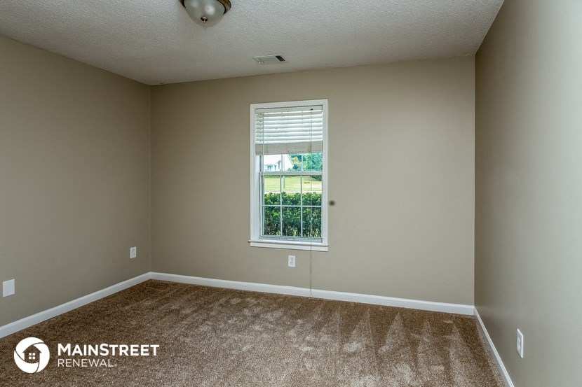 an empty room with carpet and a window