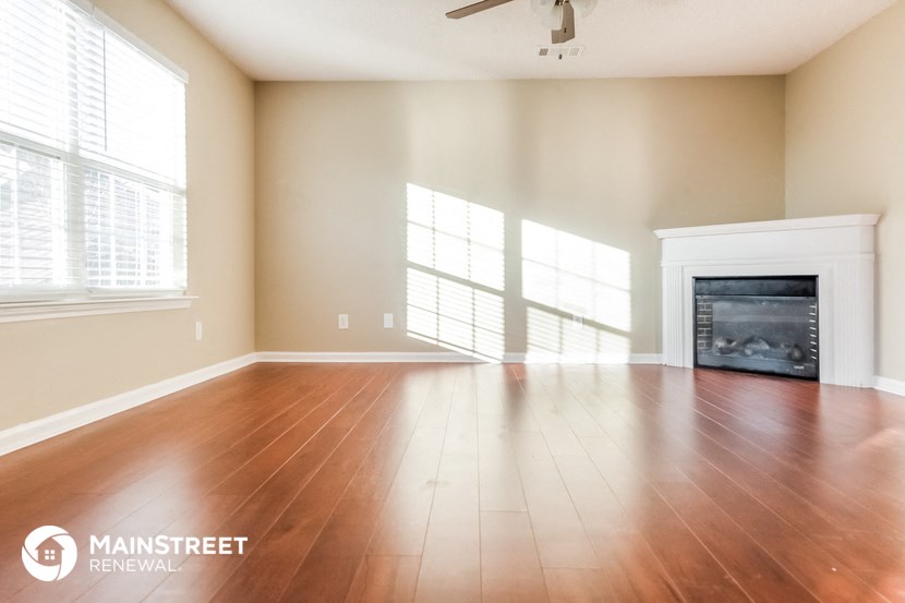 an empty living room with wood floors and a fireplace