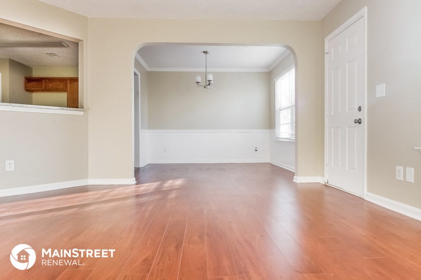 the living room and dining room with wood floors and white walls
