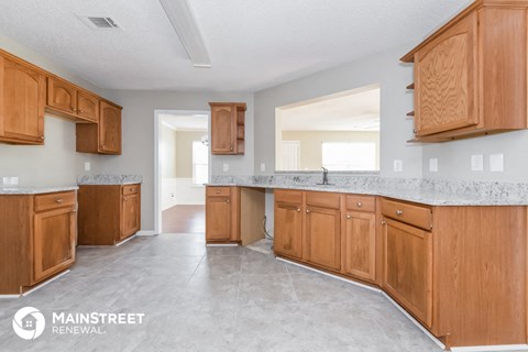 a kitchen with wooden cabinets and marble counter tops