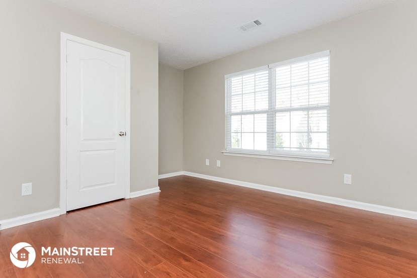 the living room of a new home with wood floors and a white door and window