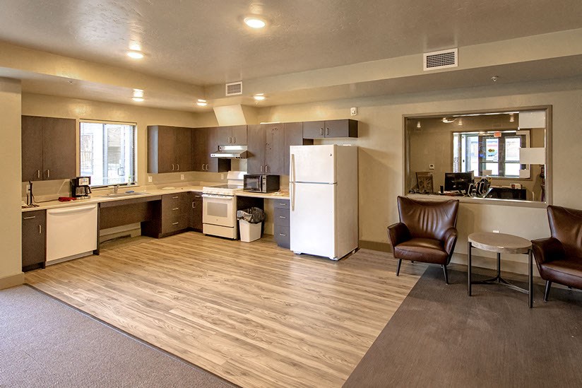 a kitchen and living room with a refrigerator and a sink