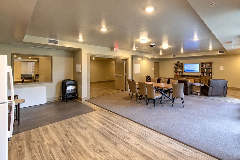 a living room and dining room with a table and a television