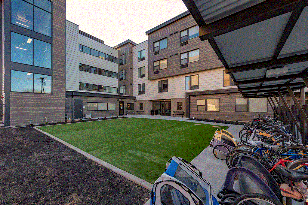 a courtyard with a lawn and bikes parked in front of a building