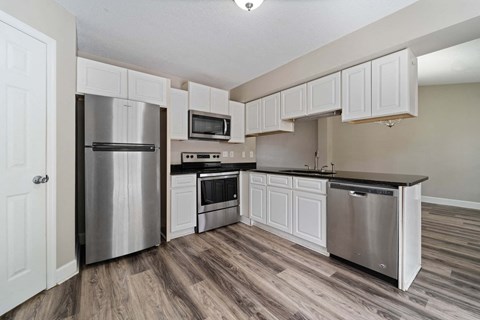 a kitchen with stainless steel appliances and white cabinets
