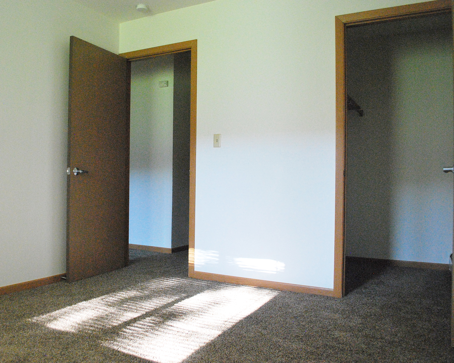 an open door in a room with sunlight shining on the floor