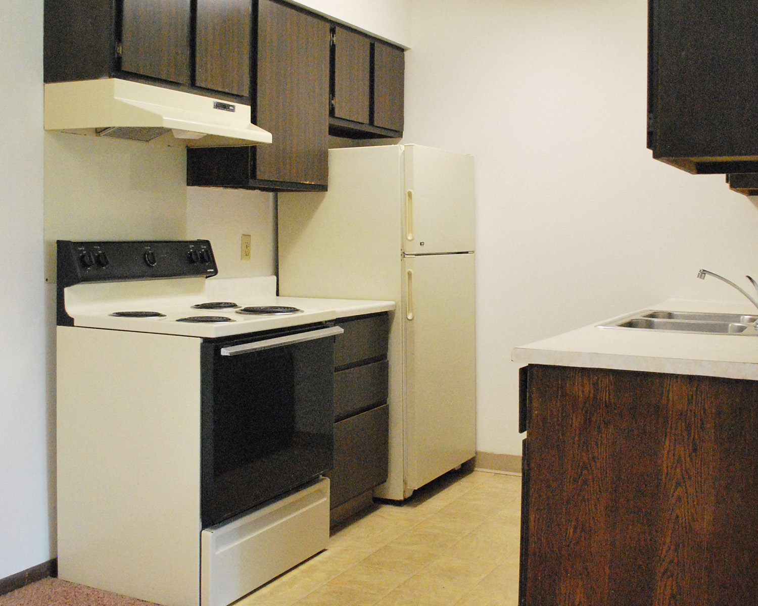 a kitchen with a stove refrigerator and a sink