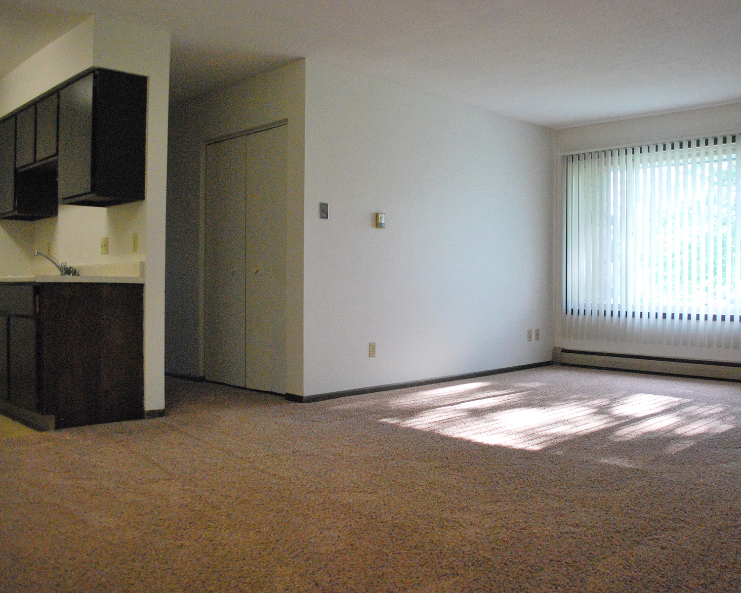an empty living room with a window and a door