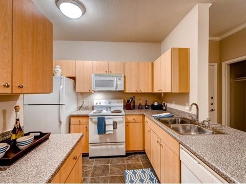 A kitchen with wooden cabinets and a white refrigerator.