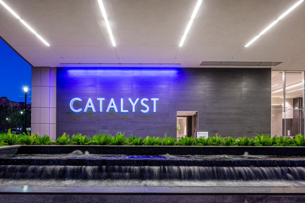 the facade of a lobby with a fountain and a catalytic sign