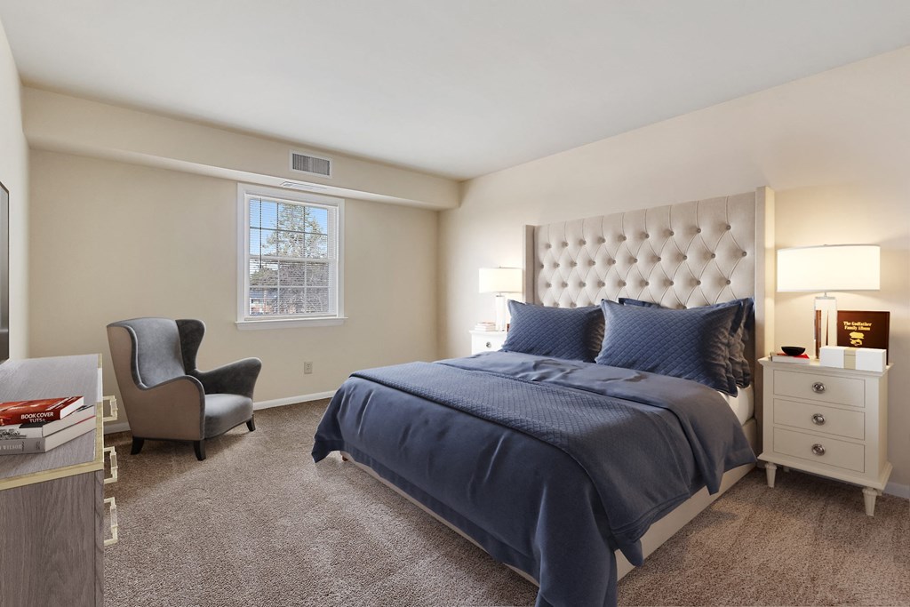 a bedroom with a bed and a chair and a window