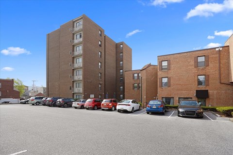 a large brick building with cars parked in a parking lot