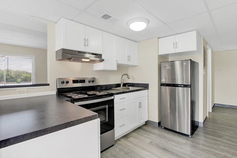 a kitchen with white cabinets and a stainless steel refrigerator