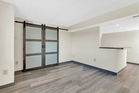 a room with white walls and wood floors and a sliding glass door