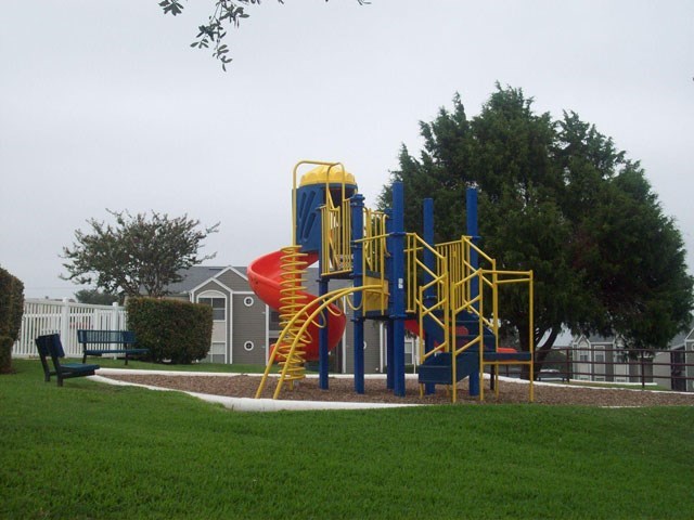 a playground with a large playset in a park