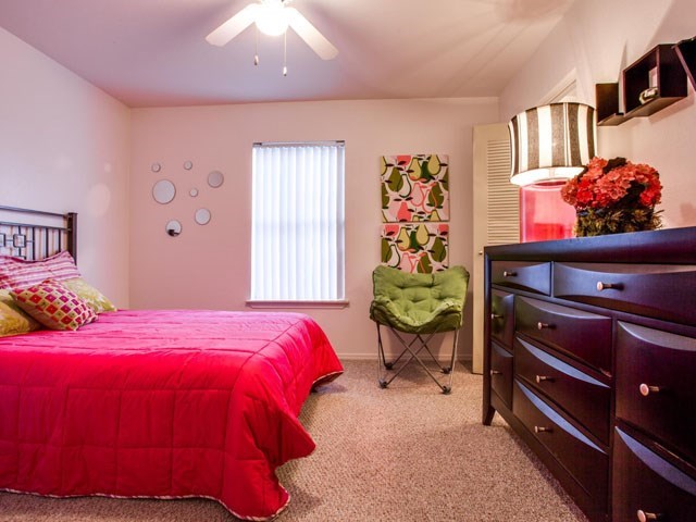 a bedroom with a bed and a chair and a dresser