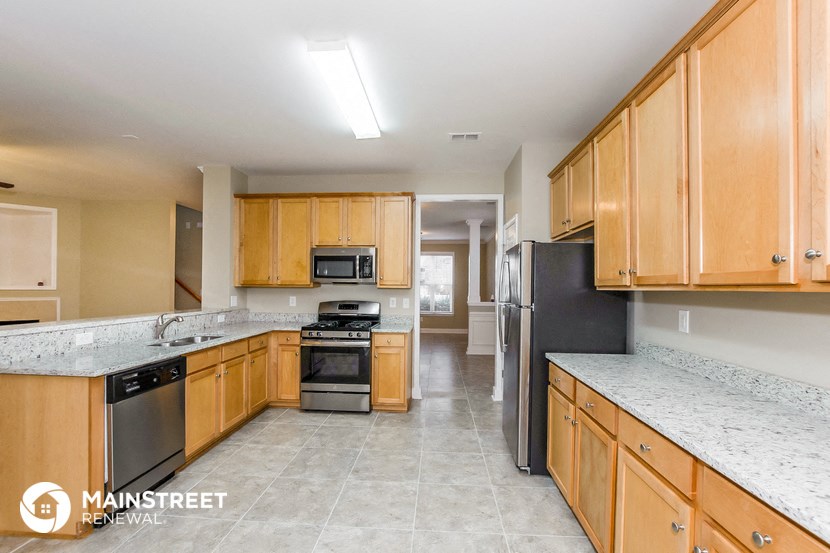 a large kitchen with wooden cabinets and stainless steel appliances