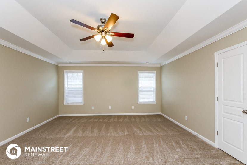 the master bedroom is spacious and has a ceiling fan