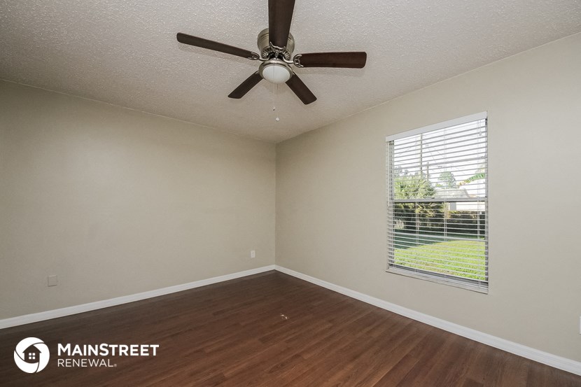 a living room with a ceiling fan and a window