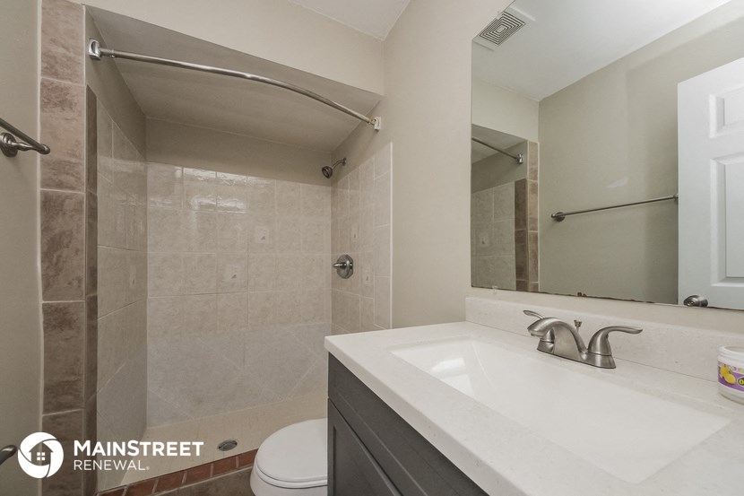 a bathroom with a sink and a shower and a mirror