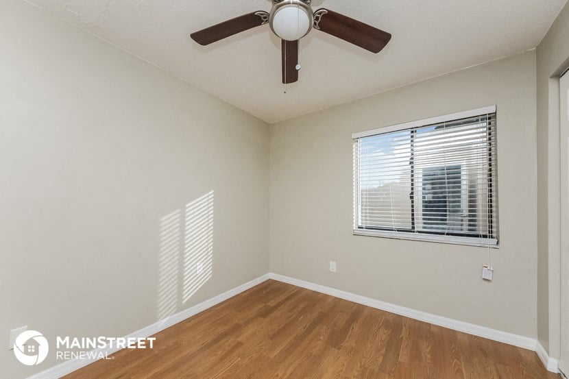 a bedroom with a ceiling fan and a window