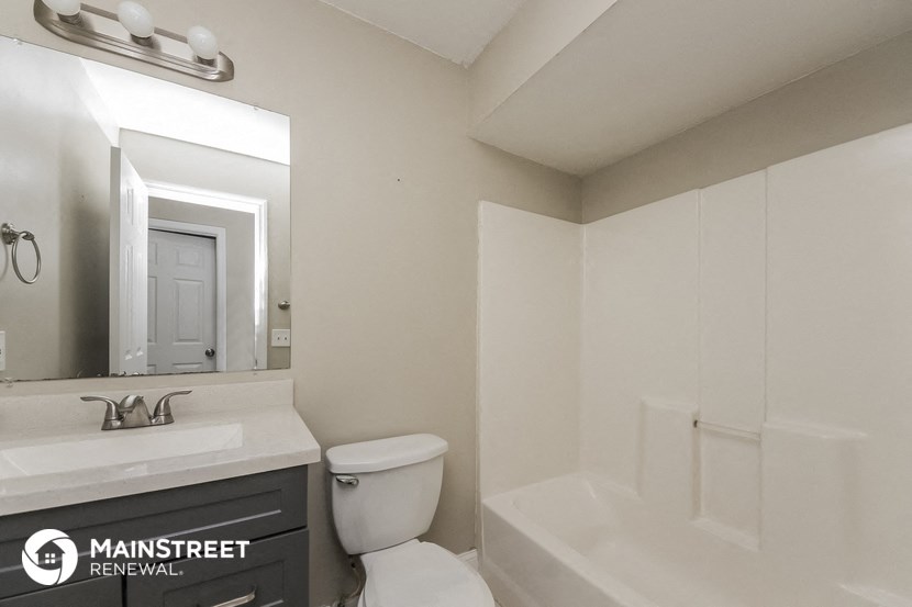 a bathroom with a toilet and a sink and a bath tub