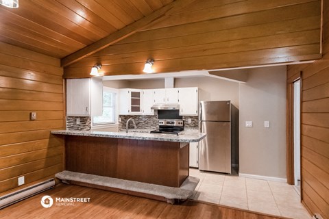 the kitchen is equipped with stainless steel appliances and a granite counter top