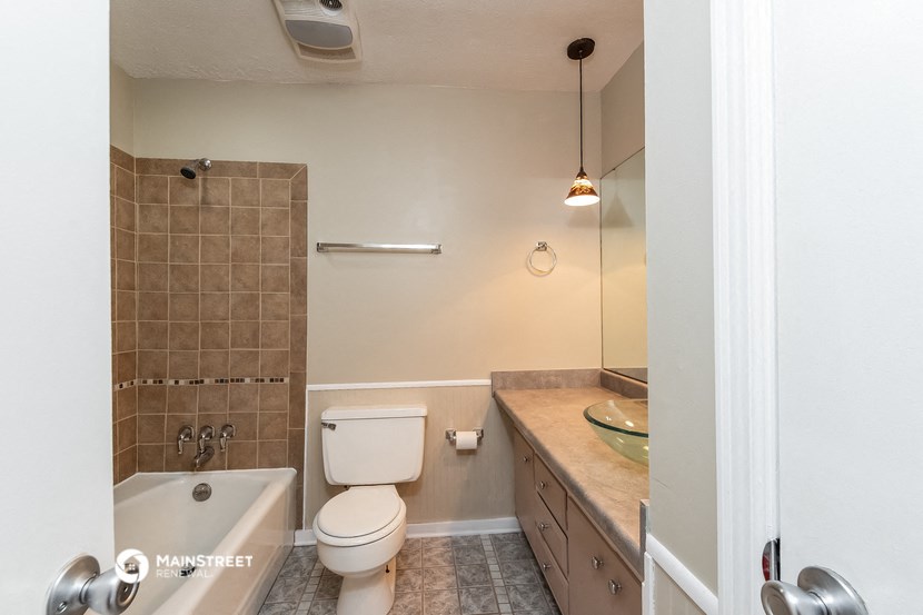 a bathroom with a toilet and a tub and a sink