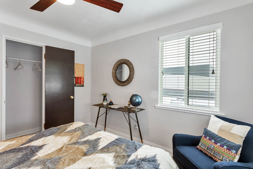 a bedroom with a bed and a chair and a closet