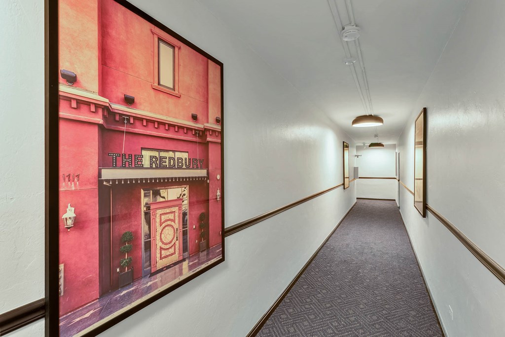 a hallway with a picture of a red building on the wall and a hall way