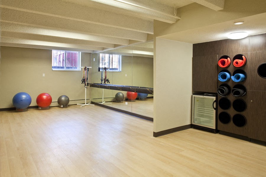 a gym with a yoga room and balls on the wall