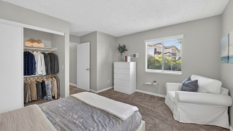 A bedroom with a bed, a couch, and a wardrobe.