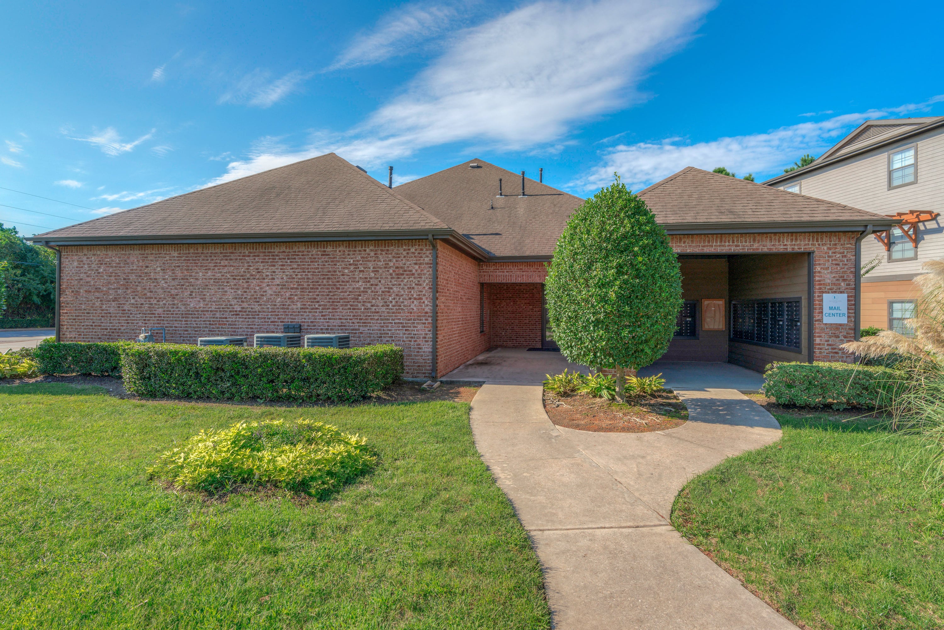 the front of a house with a walkway and grass