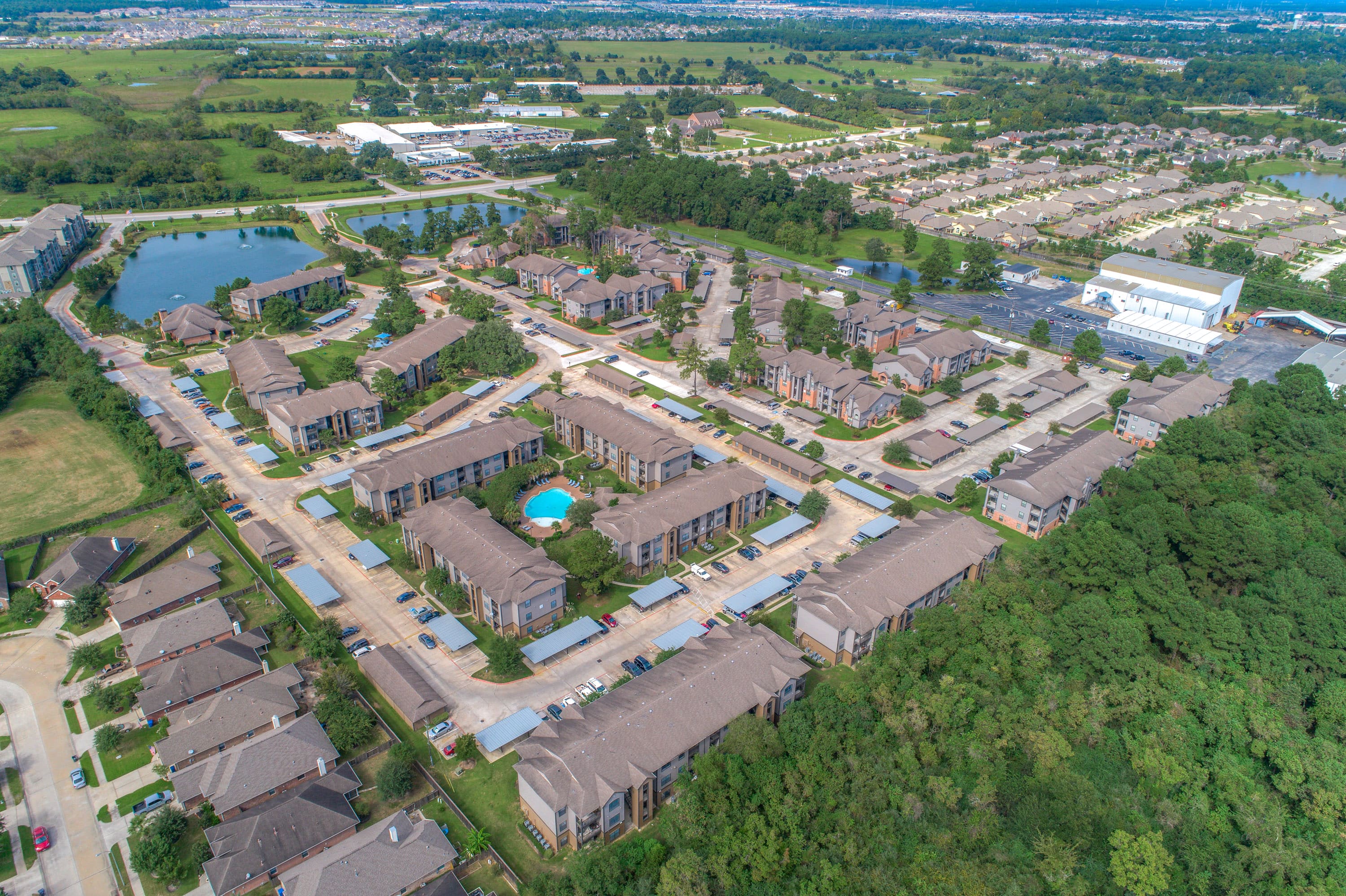 an aerial view of a city with houses and a swimming pool