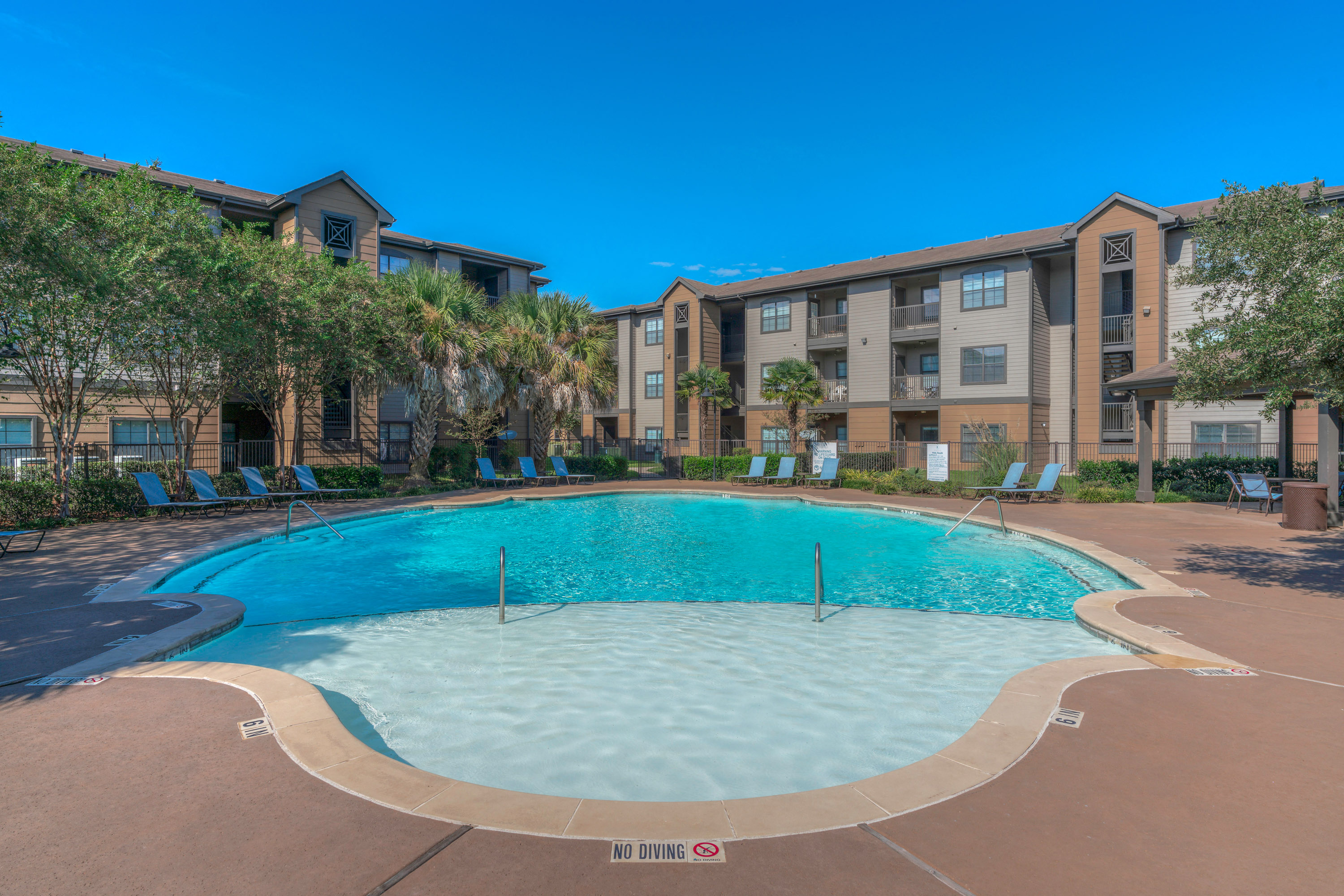 a large swimming pool with an apartment building in the background