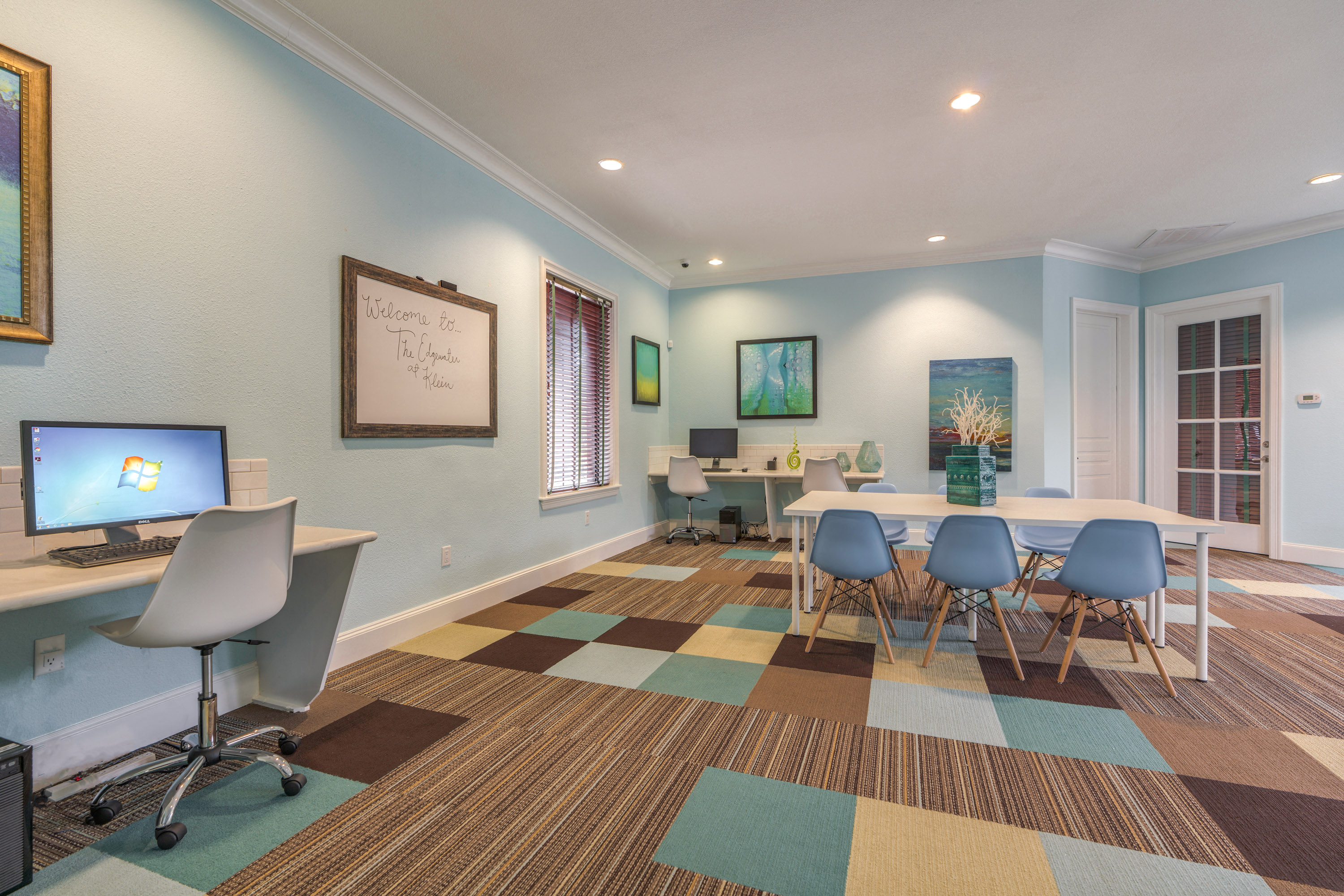 a conference room with a table and chairs and a computer