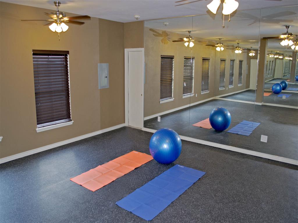 a fitness room with yoga mats and exercise balls
