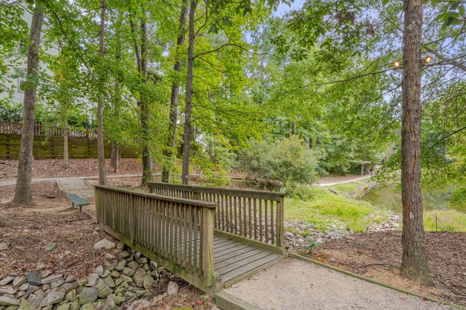 a wooden bridge in a park with trees