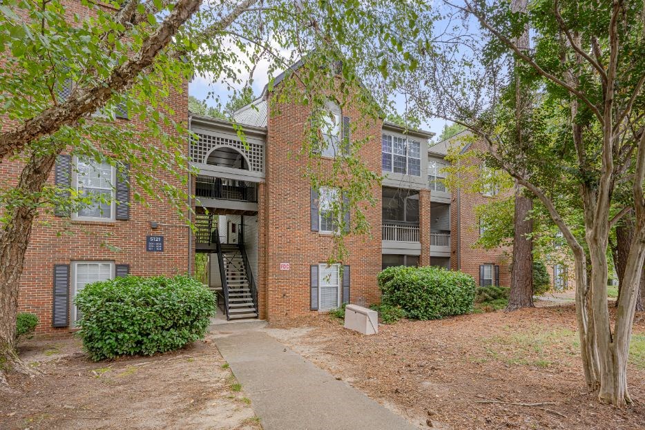 the front of a brick apartment building with trees