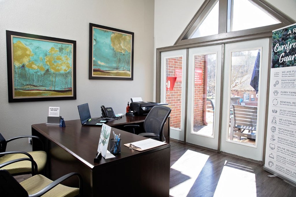 an office with a desk and chairs and a window