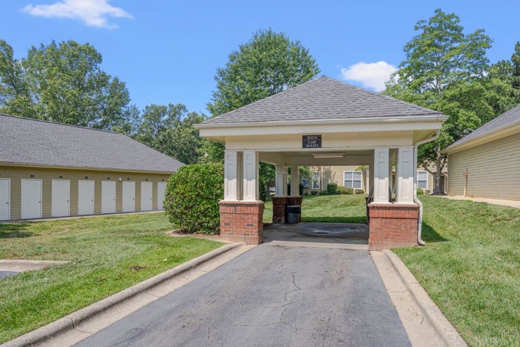 a covered porch with a driveway in front of a house