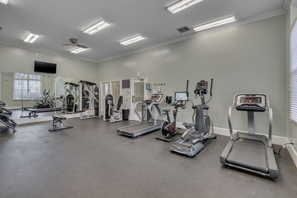 a gym with cardio equipment and weights in a building