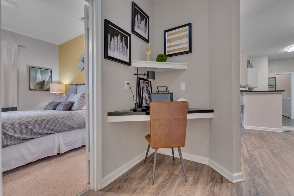 an office with a desk and a chair in a room with a bed