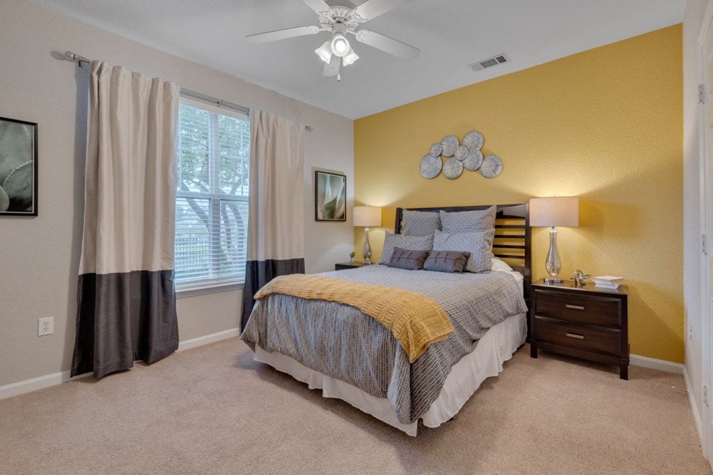 a bedroom with a bed and a ceiling fan