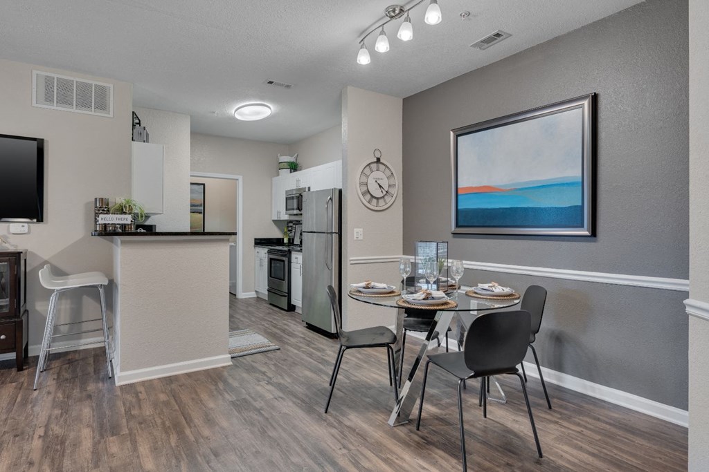 an open kitchen and dining room area with a table and chairs and a kitchen counter