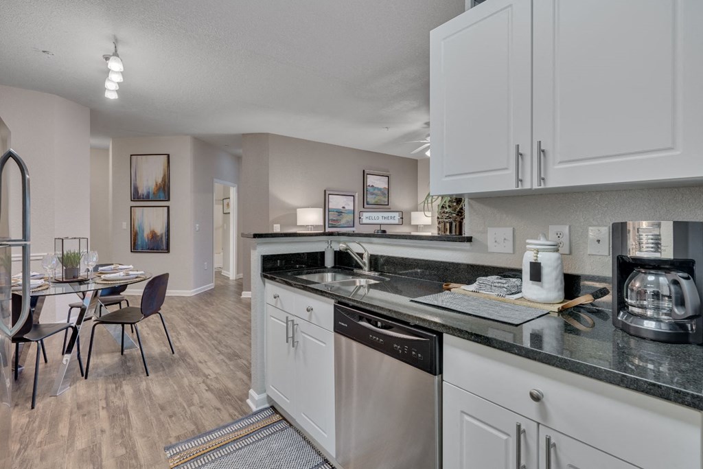 a kitchen with a dishwasher and a table with a chair
