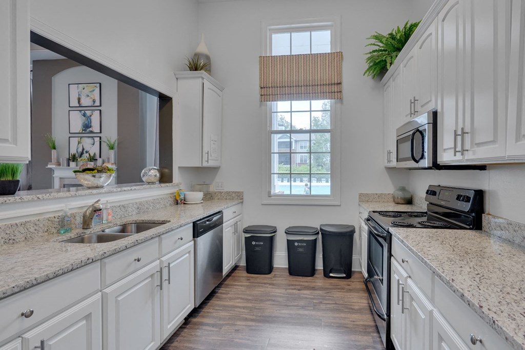 a kitchen with granite counter tops and white cabinets