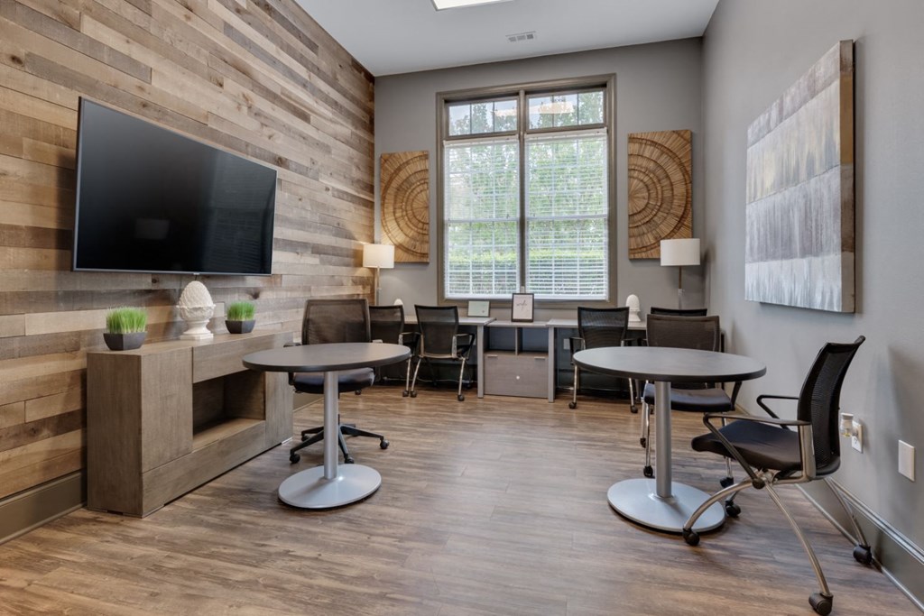 a living room with tables and chairs and a tv