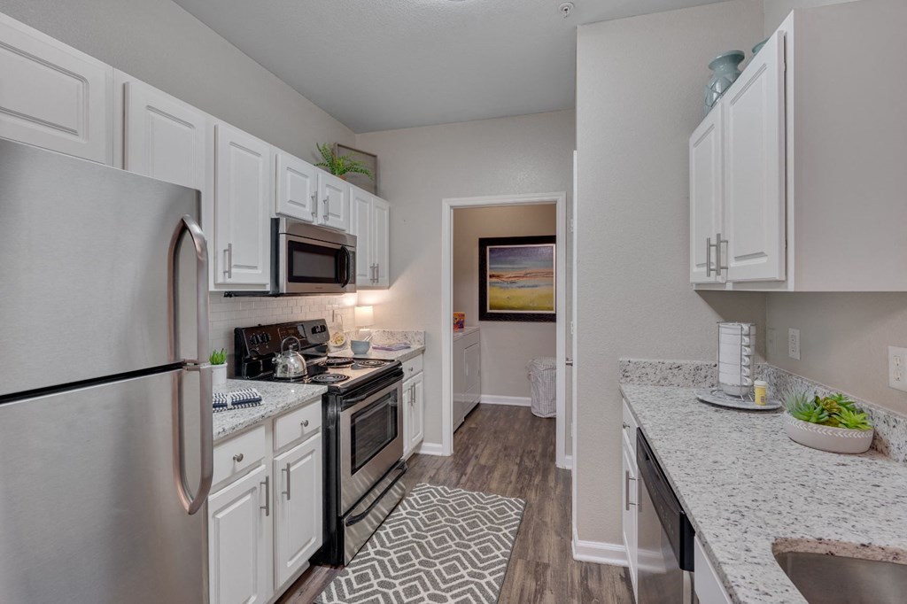 a kitchen with stainless steel appliances and white cabinets